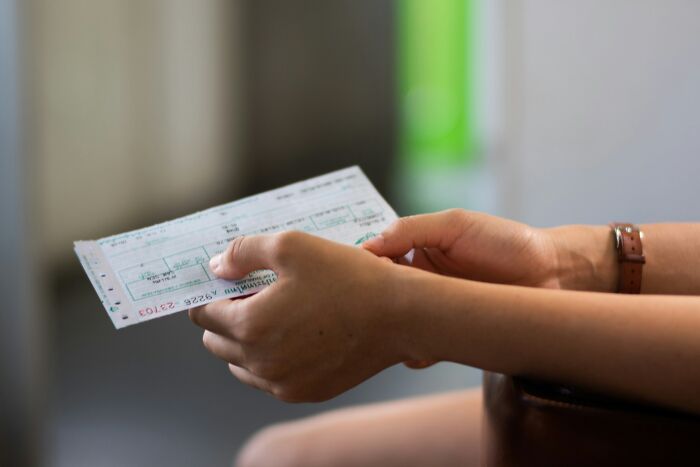 Close-up of a person holding a printed ticket or receipt amid Halloween conflicts and travel planning.
