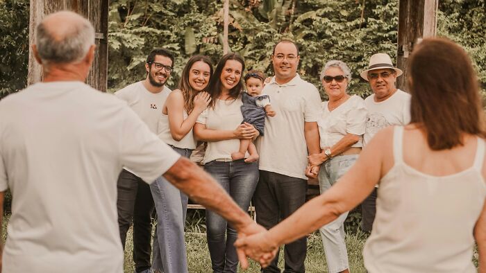 A large family gathered together outdoors smiling for a portrait.