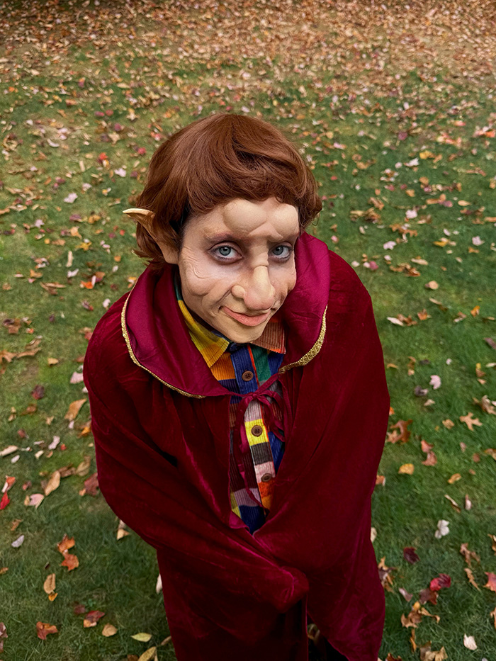 Person dressed as a hobbit wearing a red cloak for celebrity Halloween costumes