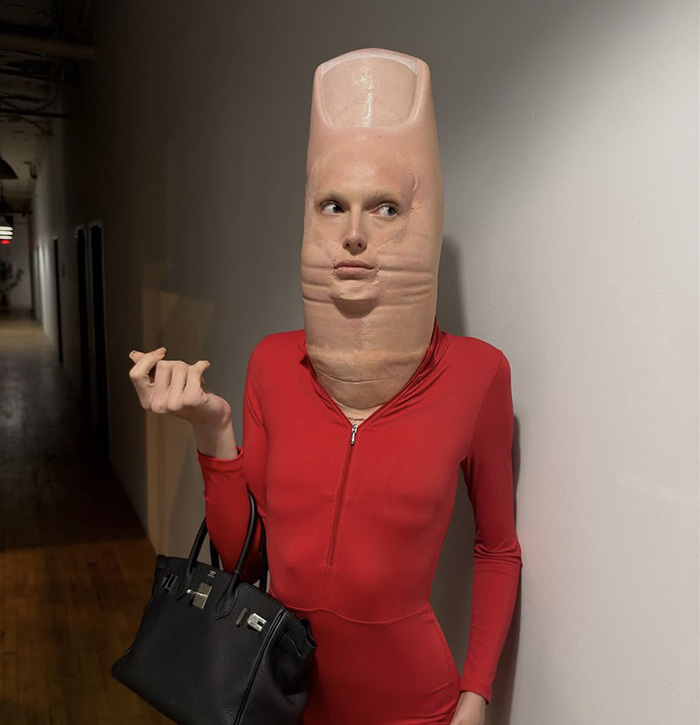 Person in red jumpsuit and giant thumb mask showing a bizarre celebrity Halloween costume