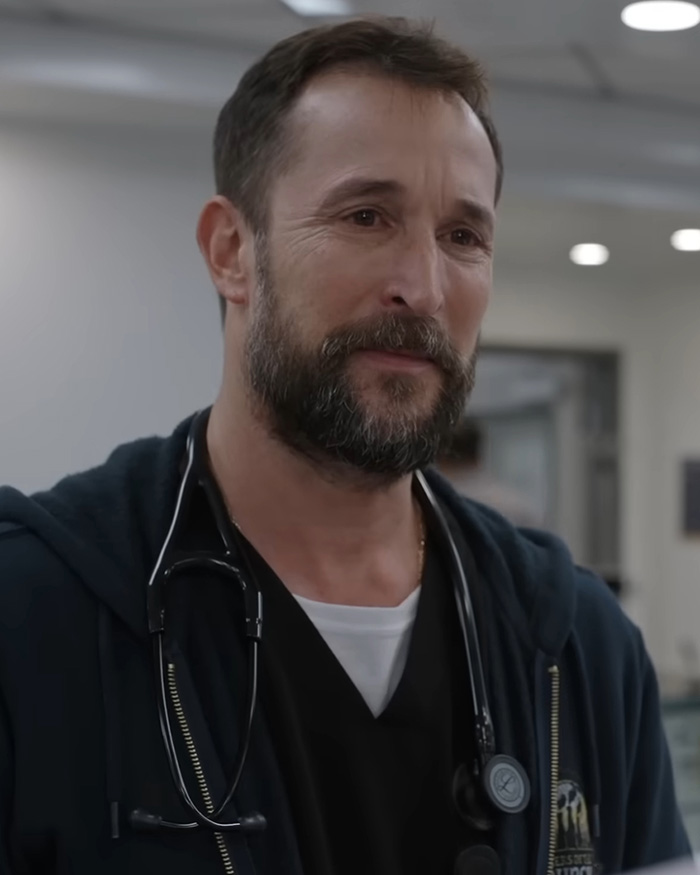Noah Wyle in medical attire with a stethoscope looking thoughtful in The Pitt Noah Wyle in medical attire with a stethoscope looking thoughtful in The Pitt