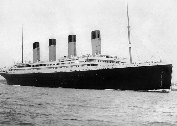 Historical black and white photograph of the Titanic ocean liner sailing on open water. Historical black and white photograph of the Titanic ocean liner sailing on open water.