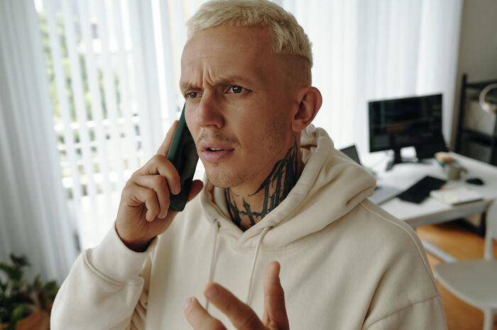 Tattooed man talking on phone with a confused look fitting quick-fire jokes