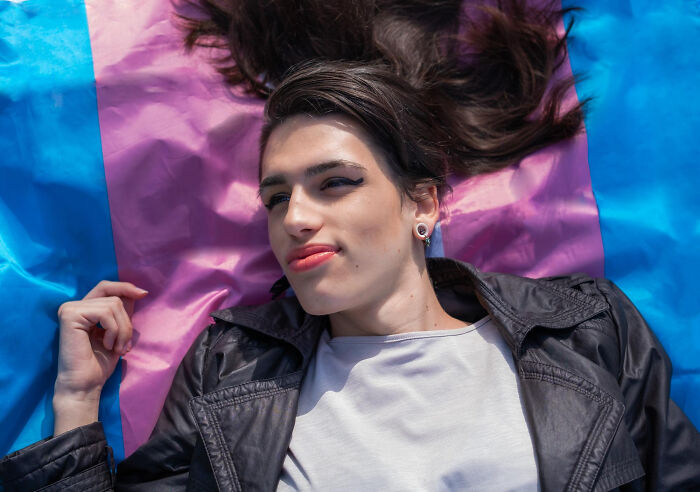 Person lying on a colorful flag enjoying quick-fire jokes outdoor