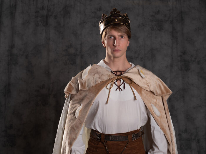 A man in a king costume and crown posing, perfect for quick-fire jokes.