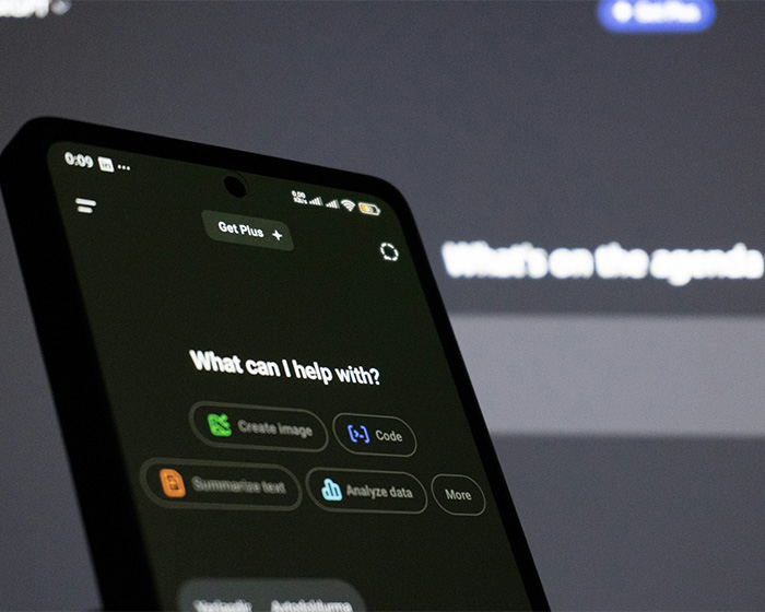 Smartphone screen displaying an AI chatbot application next to a laptop interface.