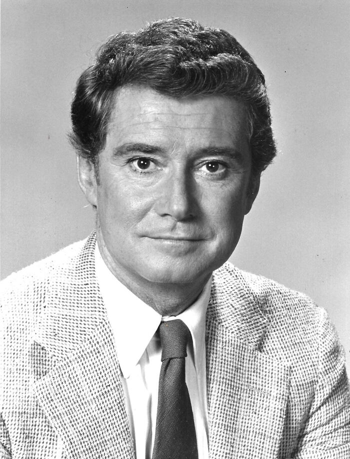 A vintage black and white portrait of a handsome man in a suit jacket, sharing true stories from the past.