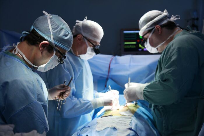 Surgeons in scrubs performing an operation in an operating room as part of true stories told by people.