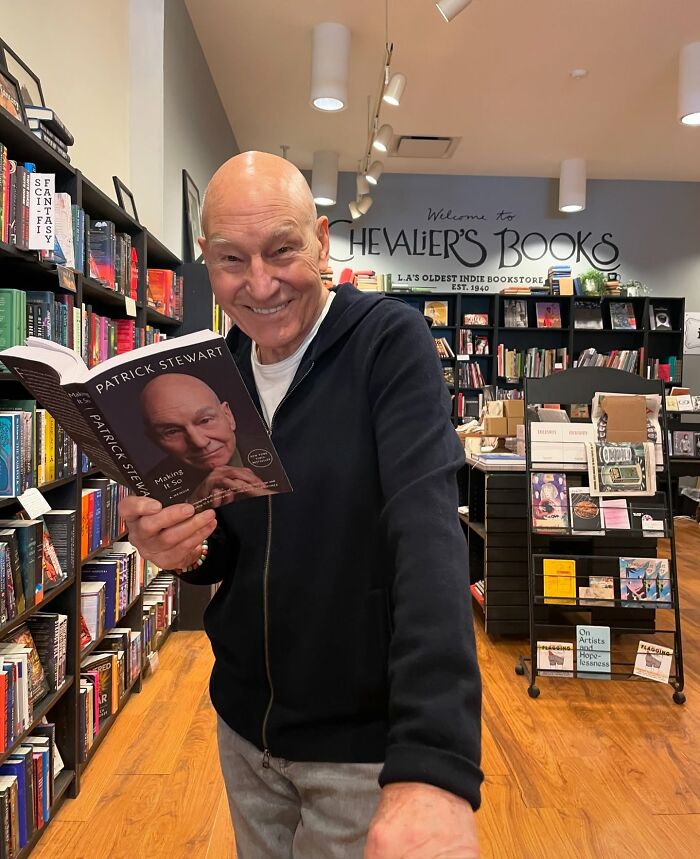 Patrick Stewart smiling while holding his autobiography book true stories concept