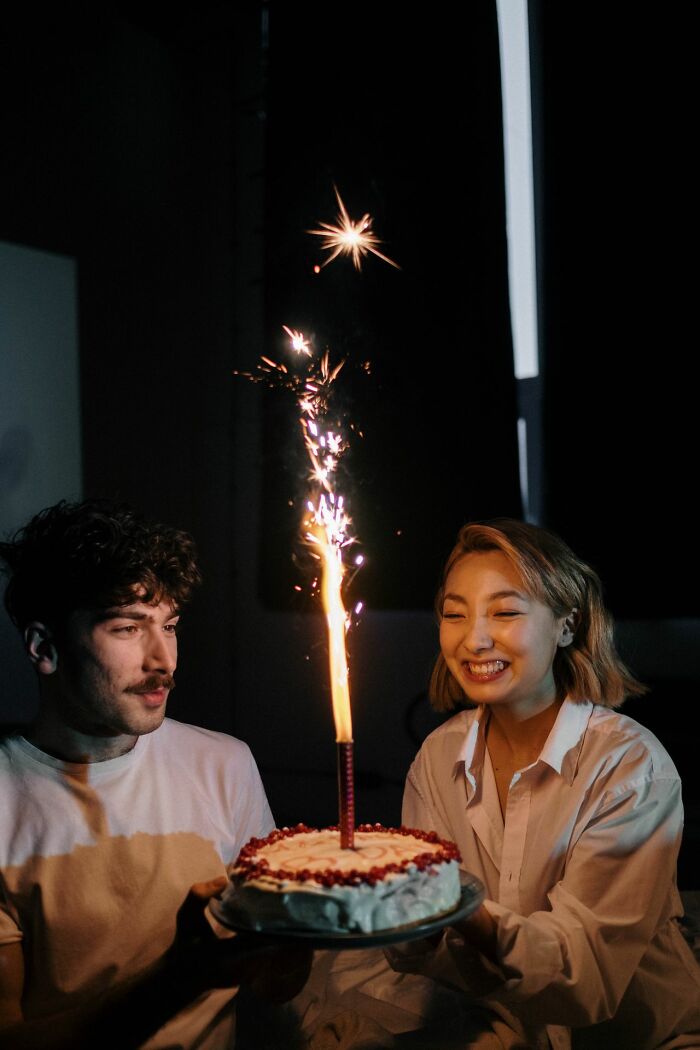 Happy couple celebrating a birthday with sparklers, telling true stories.