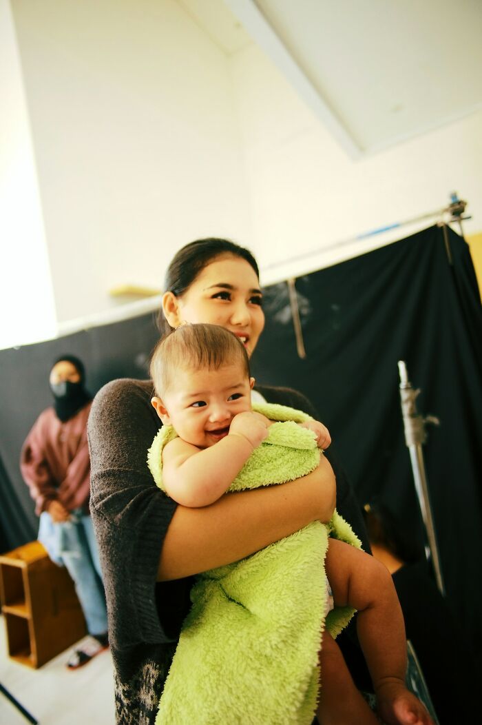 A smiling baby wrapped in a green towel, part of incredible true stories people tell.