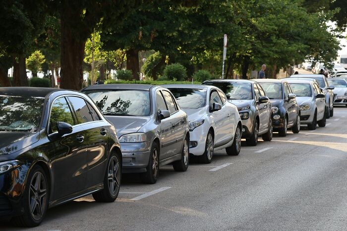 A row of cars parked on the side of a street illustrating unethical life pro tips for parking