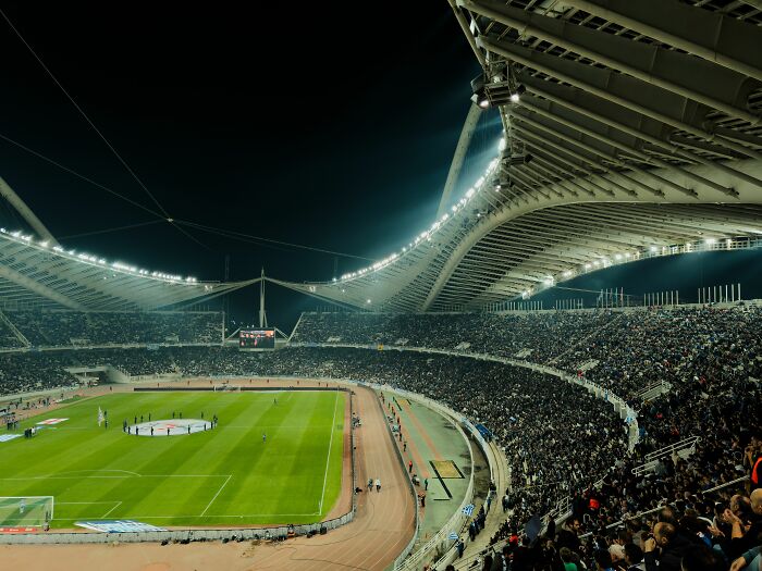 A crowded sports stadium illuminated at night, showing unethical life pro tips to get better seats
