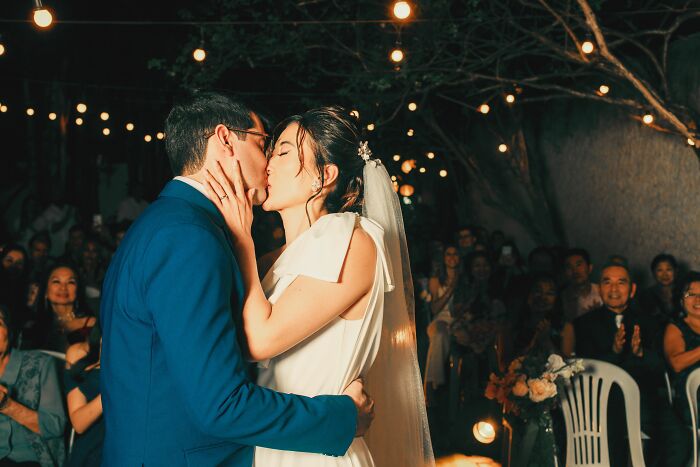 A bride and groom kissing at their wedding reception, reflecting unethical life pro tips for saving on events