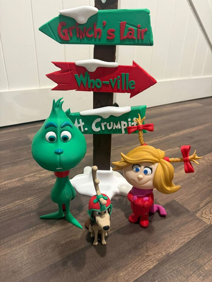 Detailed 3D printer figures of the Grinch, Cindy Lou Who, Max, and a signpost.