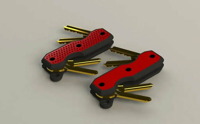 Two red and black pocket-sized key organizers made with a 3D printer.
