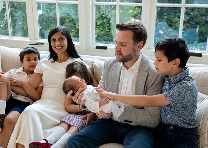 JD Vance, Second Lady Usha Vance, and their children posing for a family portrait on a white couch JD Vance, Second Lady Usha Vance, and their children posing for a family portrait on a white couch