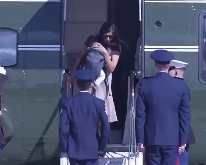 Usha Vance carrying a baby down helicopter stairs as military officers stand nearby. Usha Vance carrying a baby down helicopter stairs as military officers stand nearby.