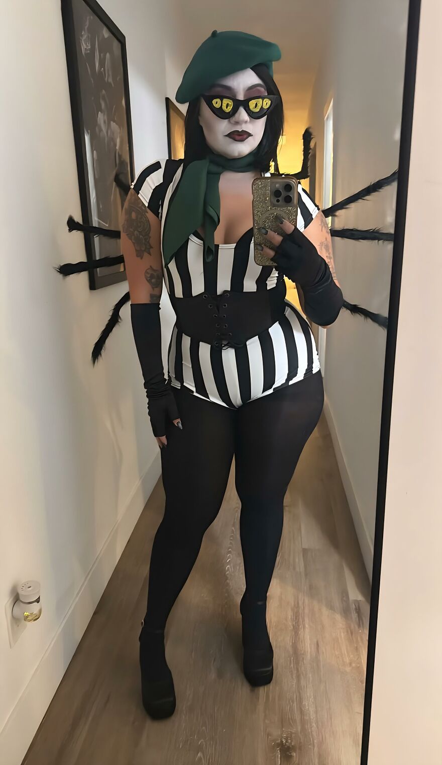 A woman wearing a spider-inspired outfit and yellow cat-eye glasses, showing off creative Halloween costume ideas.