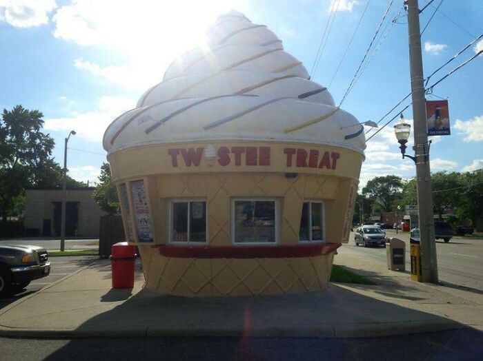 Ice cream cone shaped building labeled Twistee Treat on a sunny day