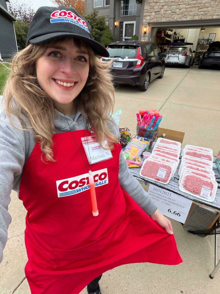 A woman wearing a Costco employee apron showcasing creative Halloween costume ideas.