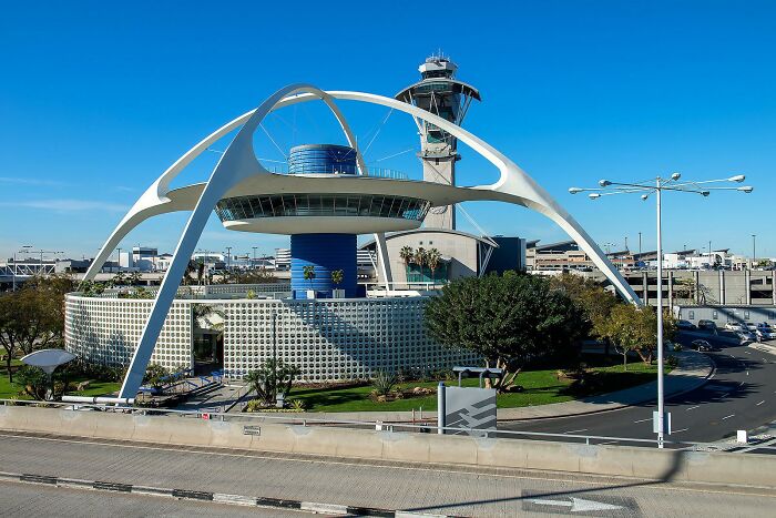 Unique strange building with futuristic arches and control tower in background