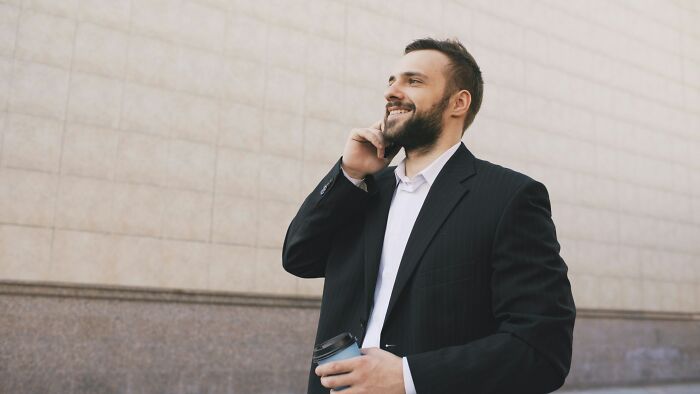 Confident businessman in suit talking on phone outdoors