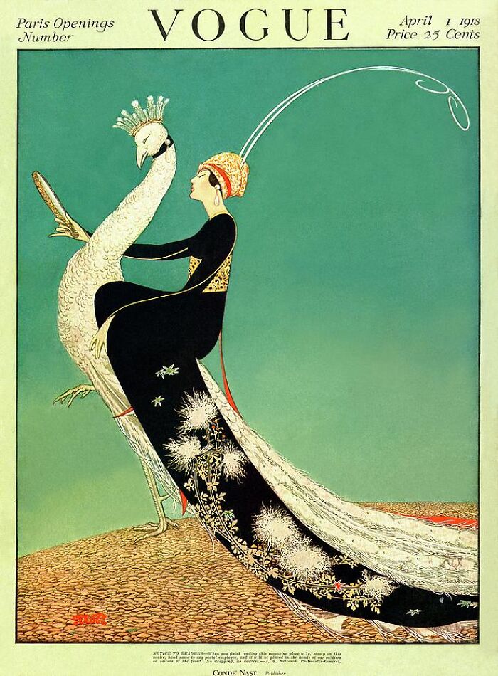 Vintage Vogue cover with art deco fashion illustration of a woman in a black gown embracing a white peacock.