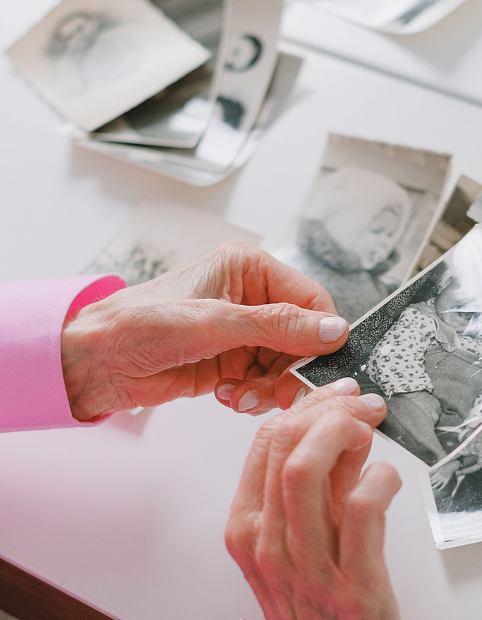 Elderly hands holding old photographs representing memory loss and Lewy Body Dementia. Elderly hands holding old photographs representing memory loss and Lewy Body Dementia.
