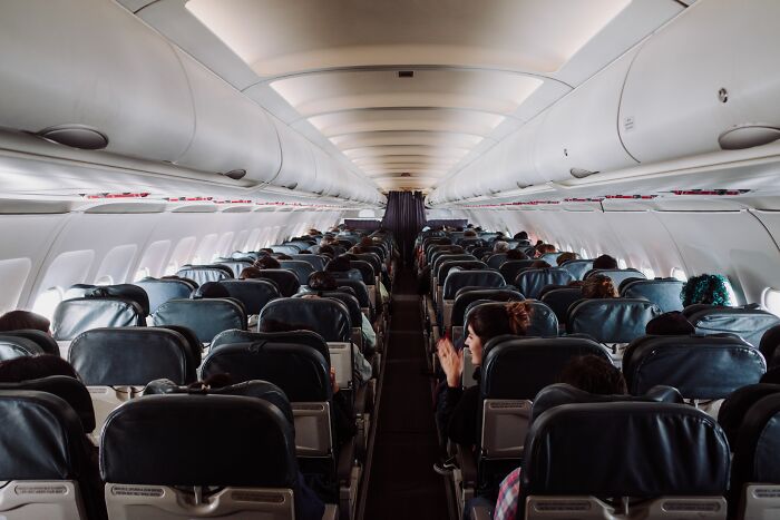 Interior of airplane cabin with seated passengers