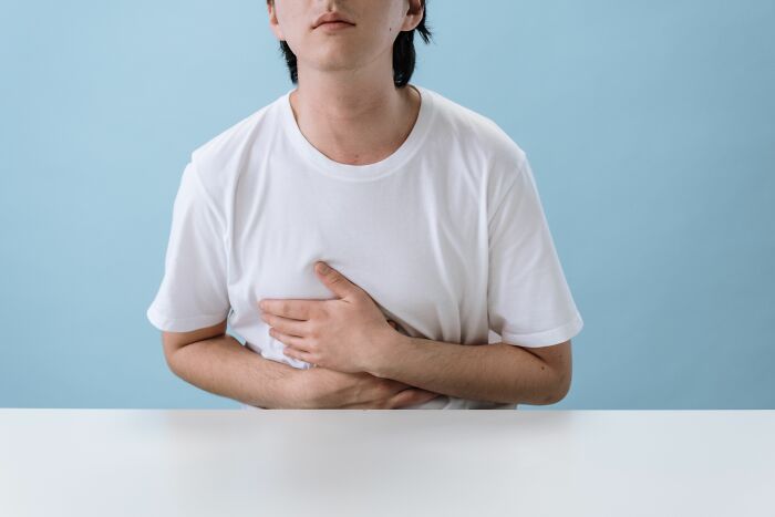 A person holding their chest demonstrating human body facts about internal organs