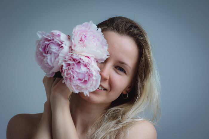 A woman holding flowers near her face exploring human body facts and senses