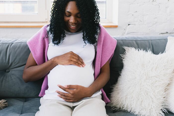 A pregnant woman holding her belly, representing human body facts during pregnancy.