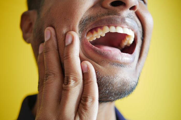 A man pointing to his teeth showing human body facts