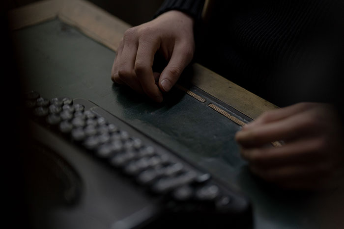 Person working with braille typewriter in a specialized transcription job