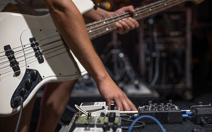 Musician adjusting sound equipment showing music jobs that are challenging but well-paid
