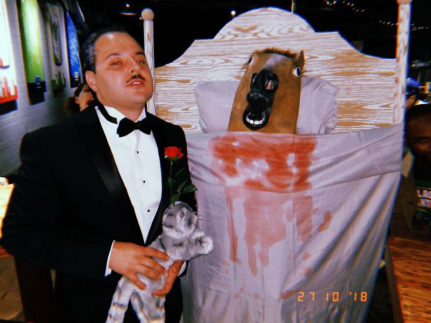 Two people in a creative Godfather-inspired Halloween costume featuring a horse head in bed.