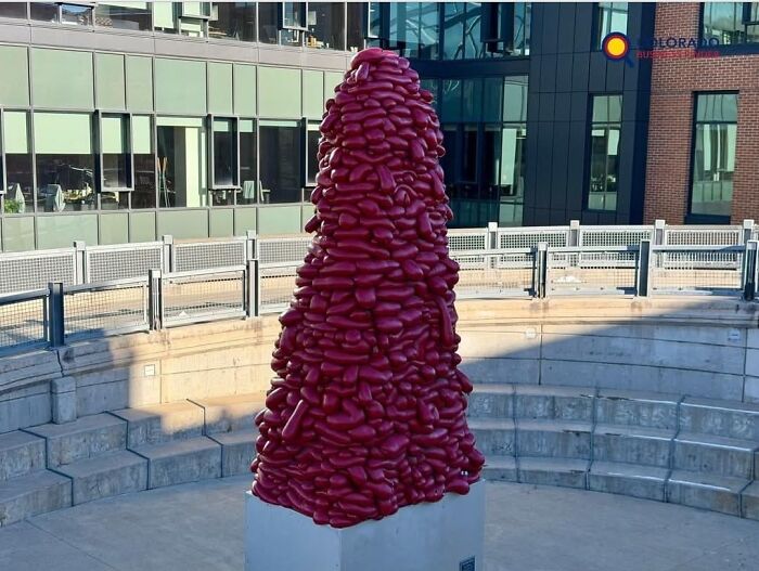 A bizarre tower of red lumpy shapes resembling beans, representing a weird piece of public art