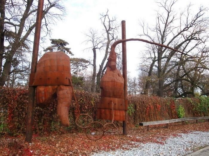 Rusty abstract metal sculptures mounted on poles in a park, illustrating bad examples of public art.