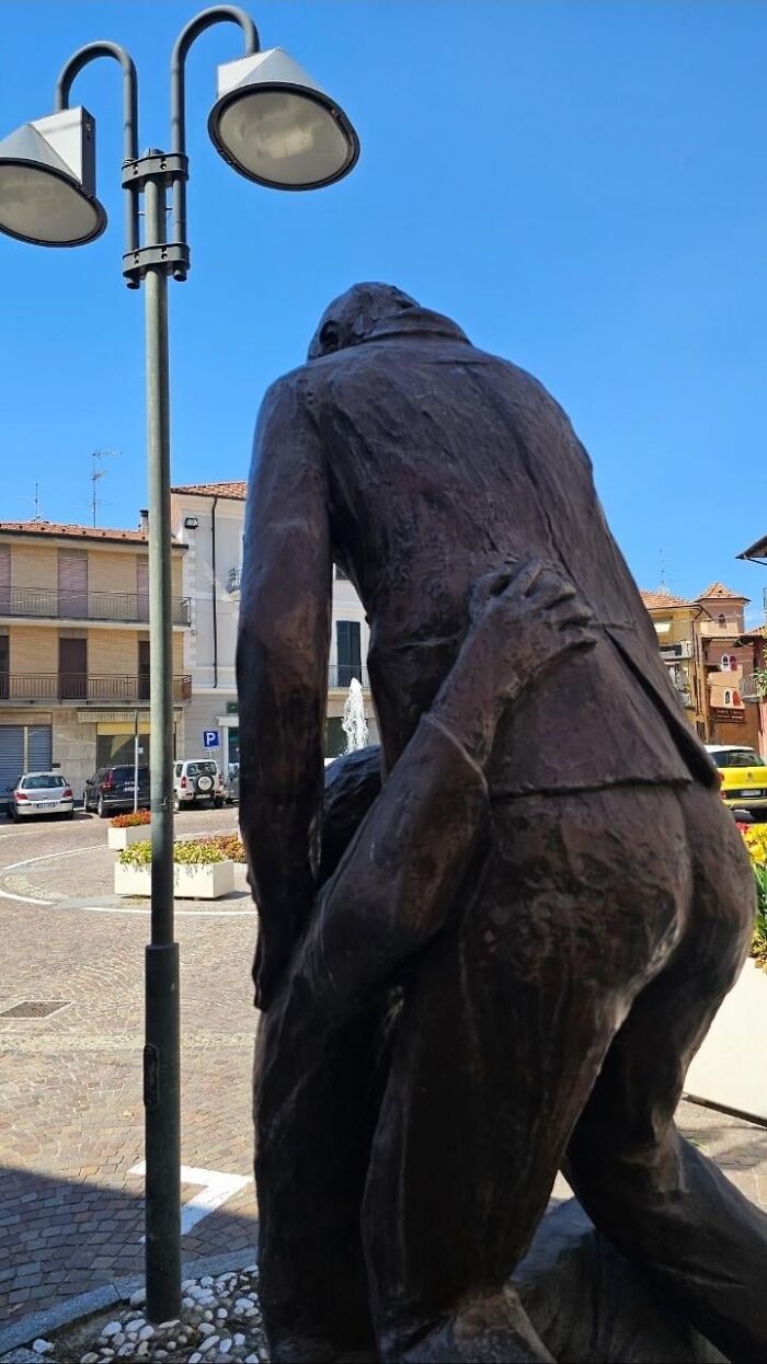 A bronze statue depicting two figures in an awkward pose, an example of strange public art.