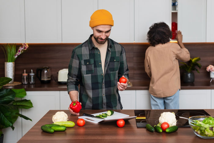 A man preparing food in a kitchen, reflecting a story about a man’s dislike for wife’s cultural cuisine. A man preparing food in a kitchen, reflecting a story about a man’s dislike for wife’s cultural cuisine.