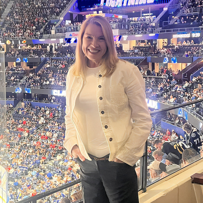 Woman at crowded sports event smiling, relating to cancer diagnoses Woman at crowded sports event smiling, relating to cancer diagnoses