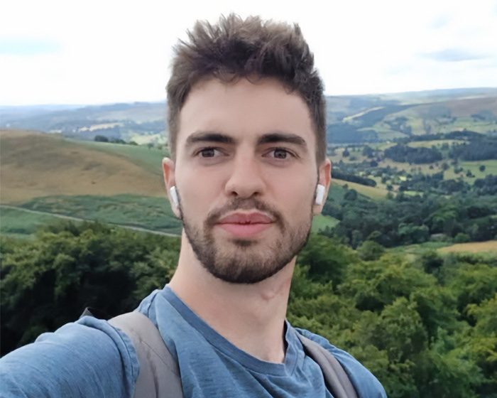 Young man taking selfie with scenic landscape behind at UK wildlife park Young man taking selfie with scenic landscape behind at UK wildlife park