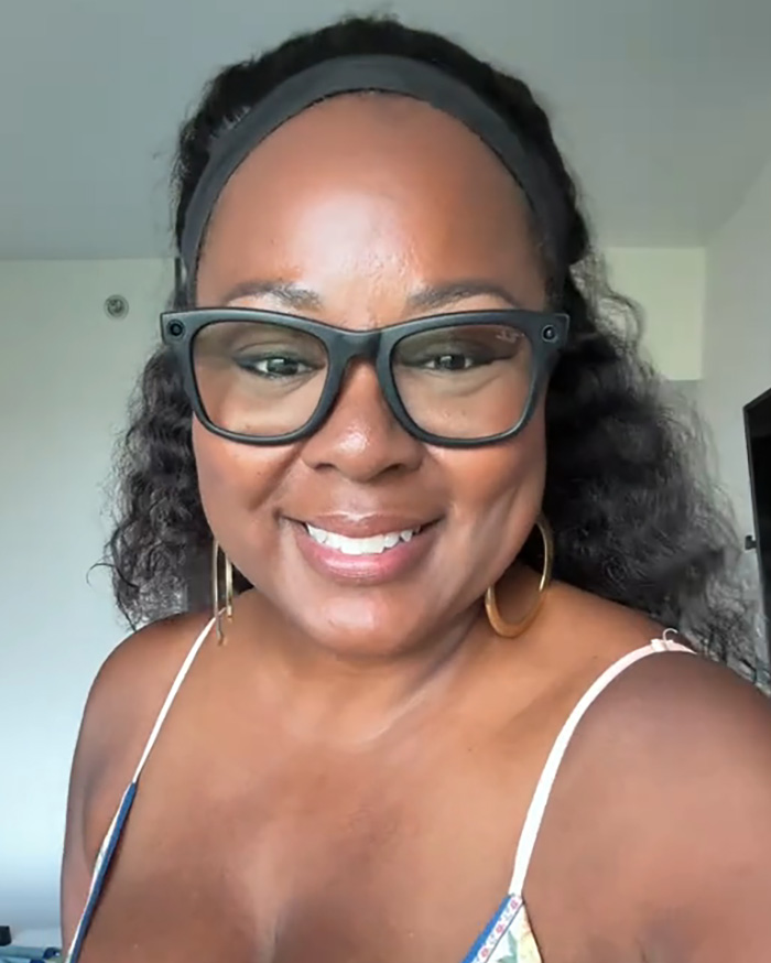 Woman smiling wearing glasses and headband at home