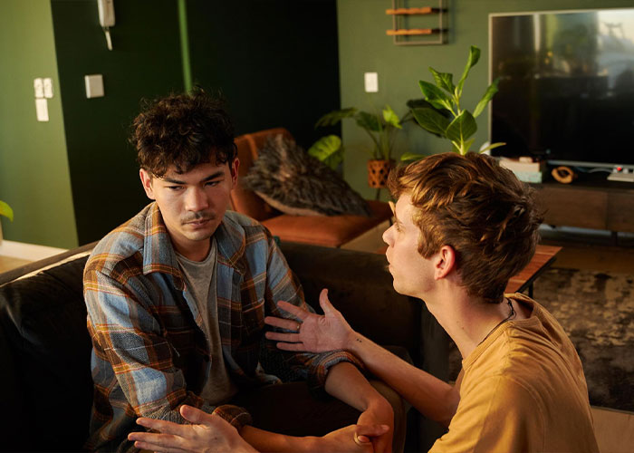 Two men in a serious conversation, depicting a man getting lied to by his partner. Two men in a serious conversation, depicting a man getting lied to by his partner.