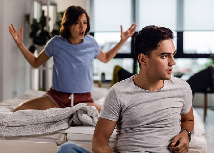 Woman arguing angrily with a man sitting on a bed, illustrating relationship conflict over a fiancé’s lie. Woman arguing angrily with a man sitting on a bed, illustrating relationship conflict over a fiancé’s lie.