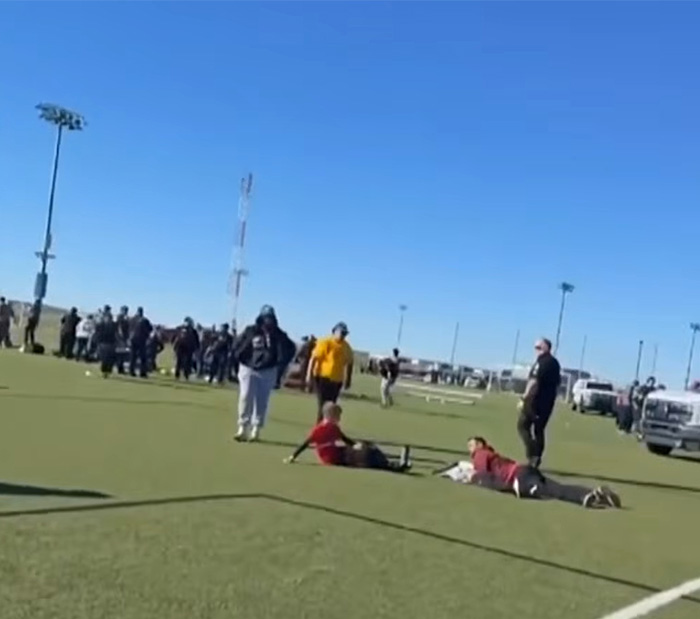 People and emergency responders gathering on a soccer field after vehicle incident at youth soccer game People and emergency responders gathering on a soccer field after vehicle incident at youth soccer game