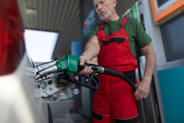 A gas station worker refueling a car, tied to sobering stories of costly everyday errors.