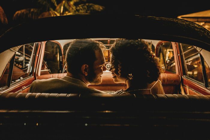 Romantic couple sitting in vintage car at night