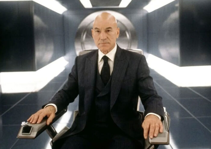 Patrick Stewart in a dark suit sitting in Professor X’s wheelchair inside Cerebro. Patrick Stewart in a dark suit sitting in Professor X’s wheelchair inside Cerebro.